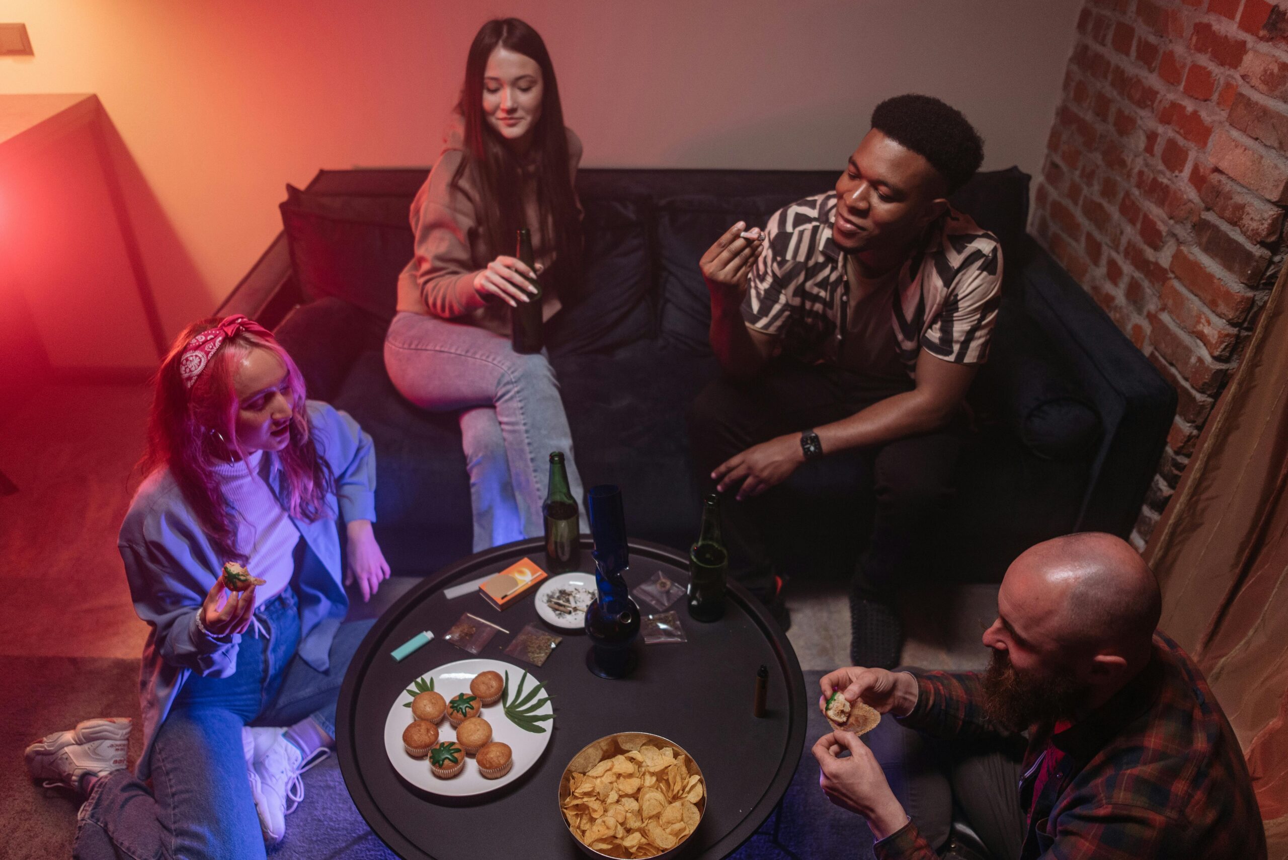 Group of friends enjoying snacks and beverages in a cozy indoor setting.